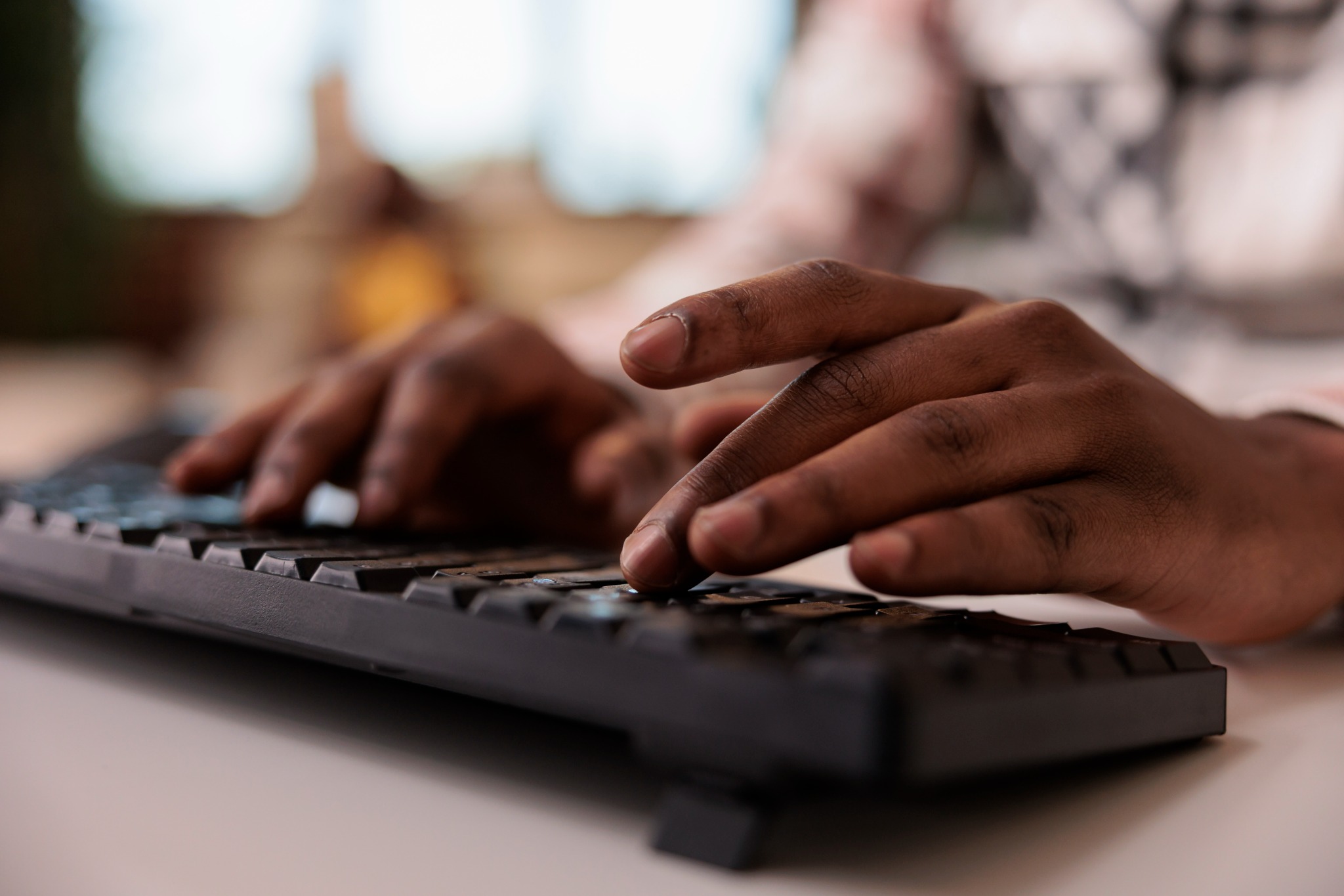 Close-up of hands typing on a keyboard